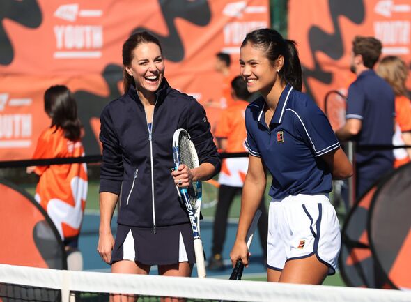 Kate laughing holding a tennis racket