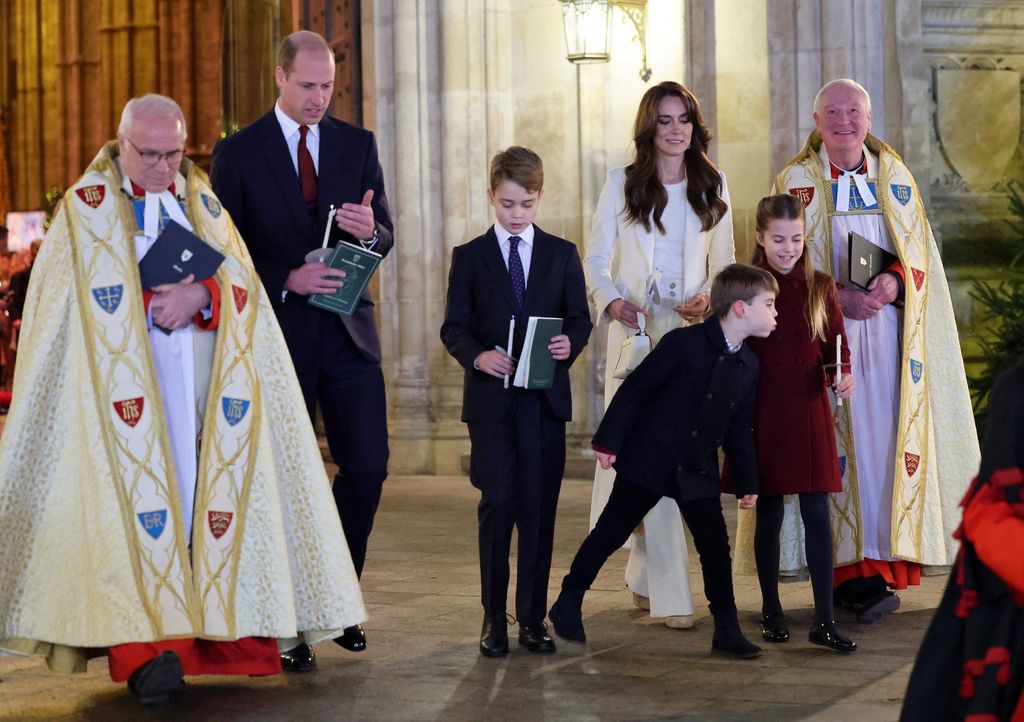 Prince Louis blowing out Princess Charlotte's christmas candle 